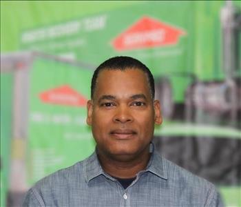 a man in a collared shirt in front of a green background