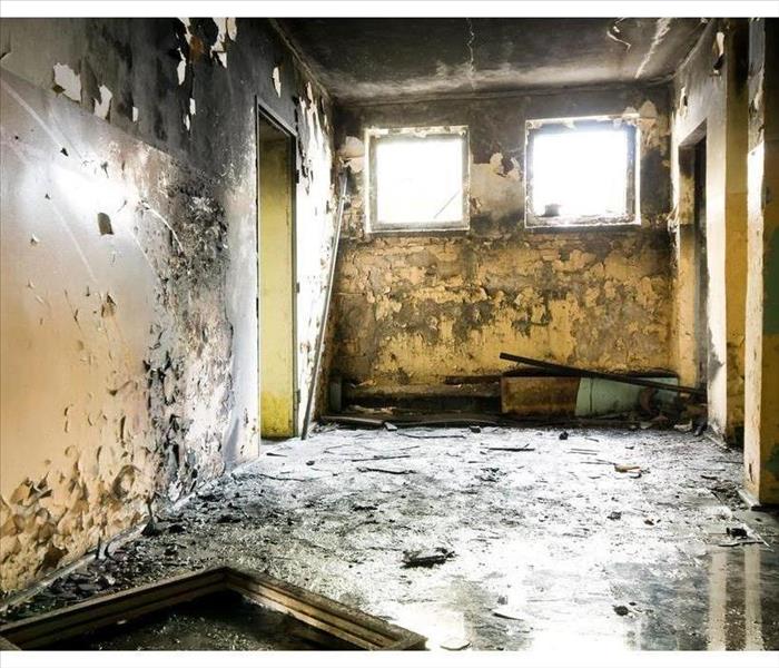 Walls and ceiling covered with smoke and soot, wet floor