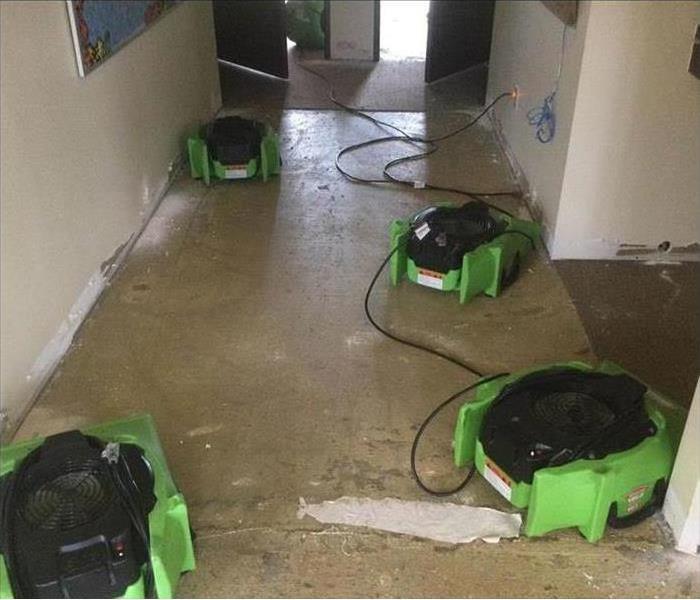 Drying equipment placed on floor, floor has been removed due to water damage